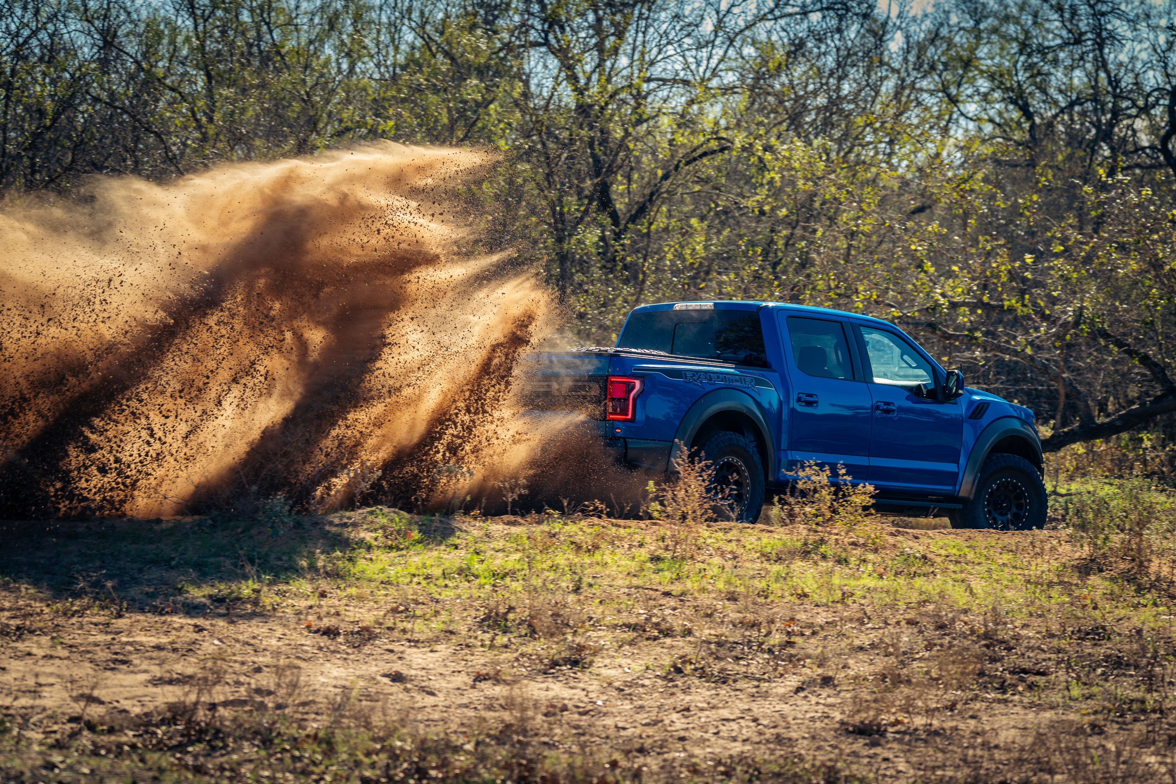 Ford Raptor dust roost — dramatic side angle