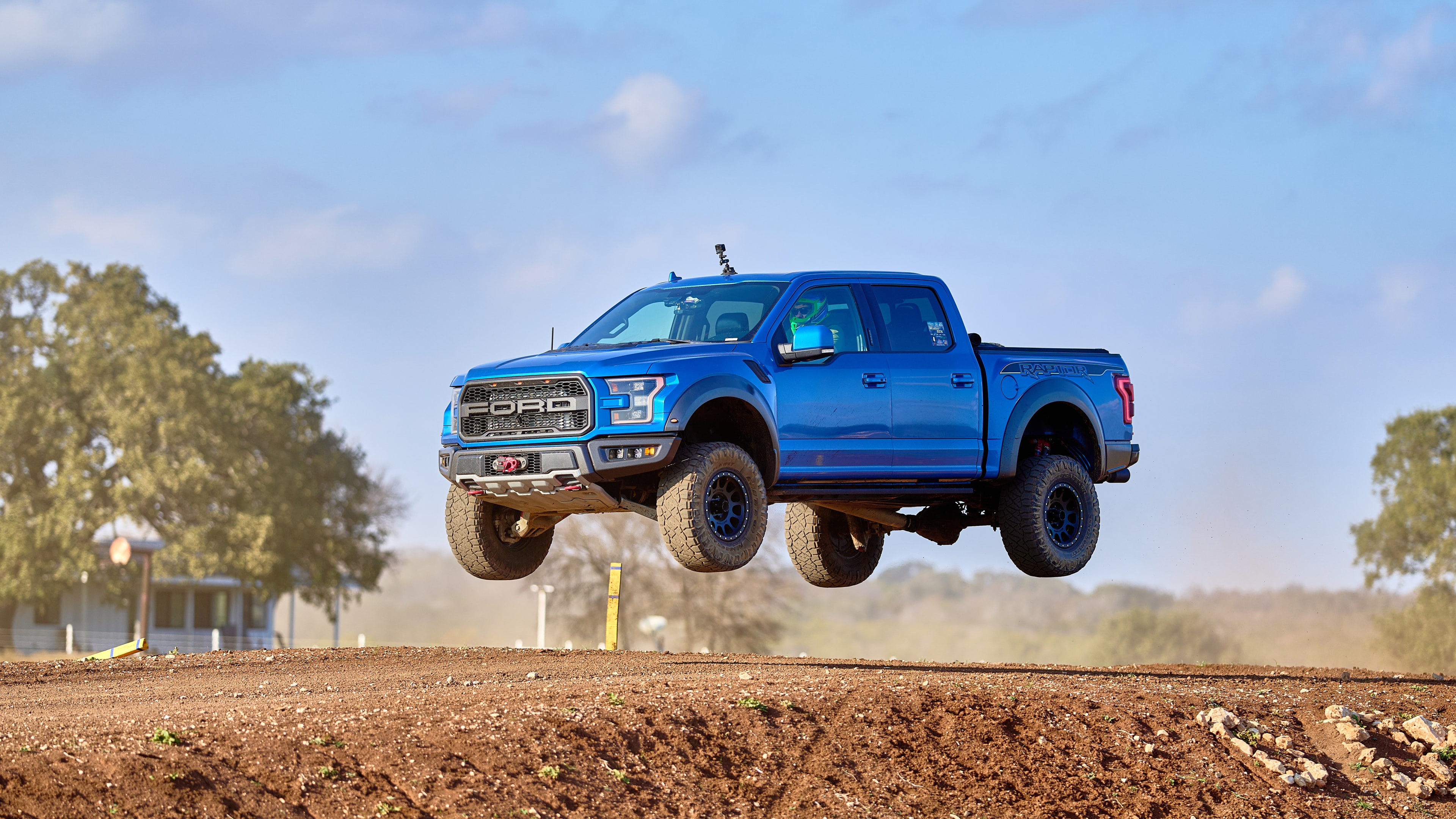 Ford Raptor two-wheel balance on dirt road